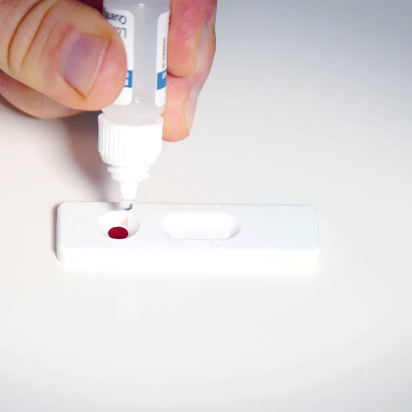 Test durchführen: Tropfen Verdünnungsmittel werden auf die Testkassette gegeben